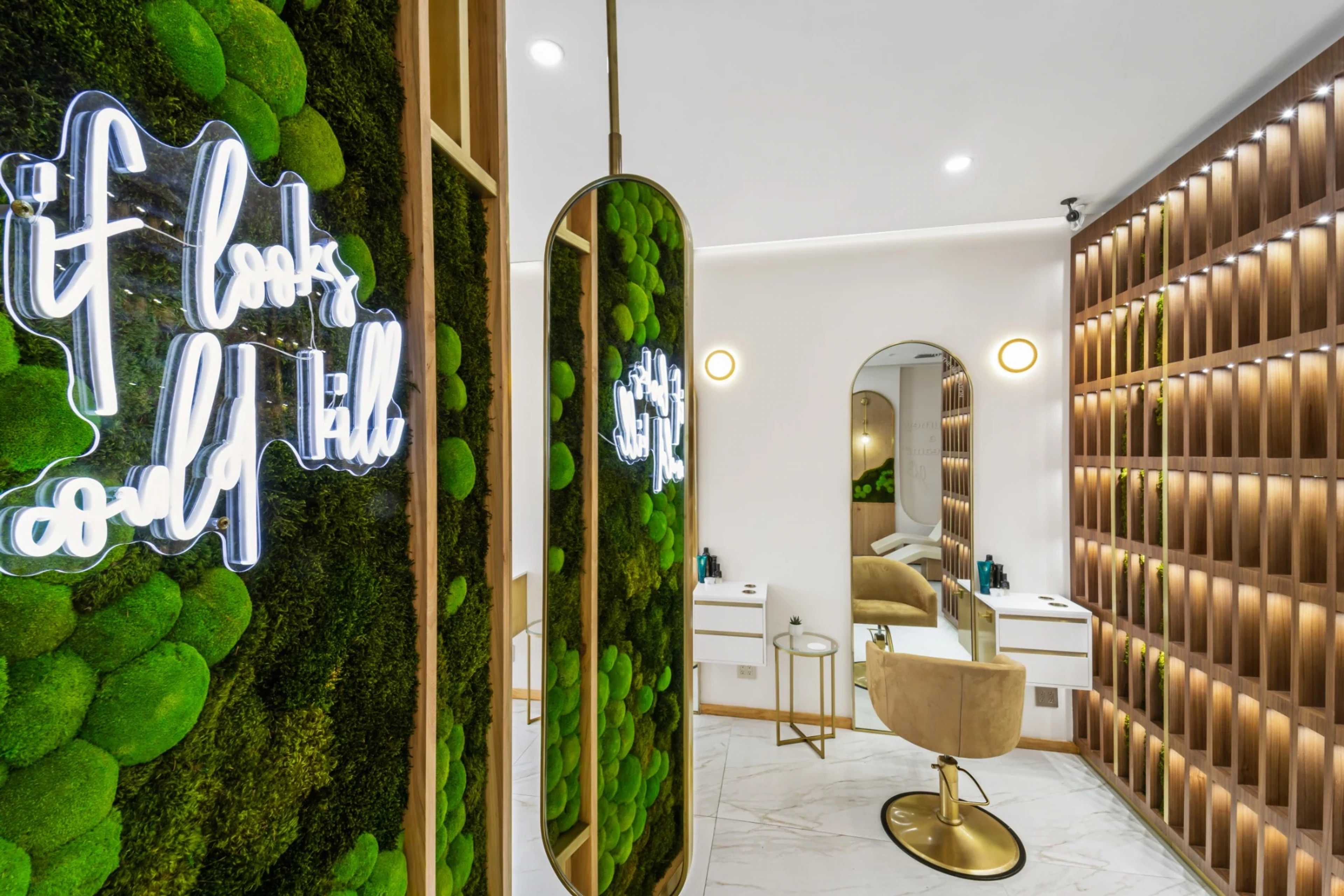 Rové’s moss feature wall beside the brass mirrors and styling chairs