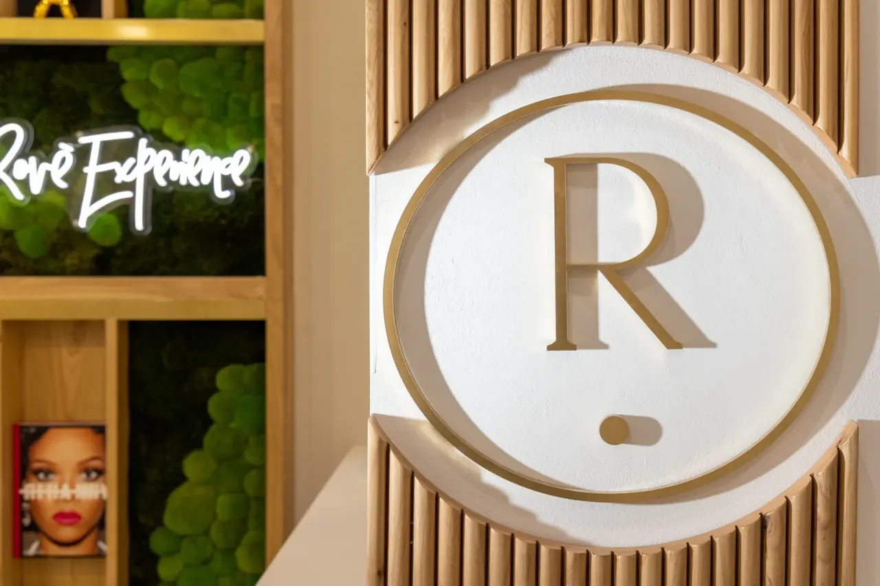 Rové’s round brass monogram against fluted oak and the moss feature wall