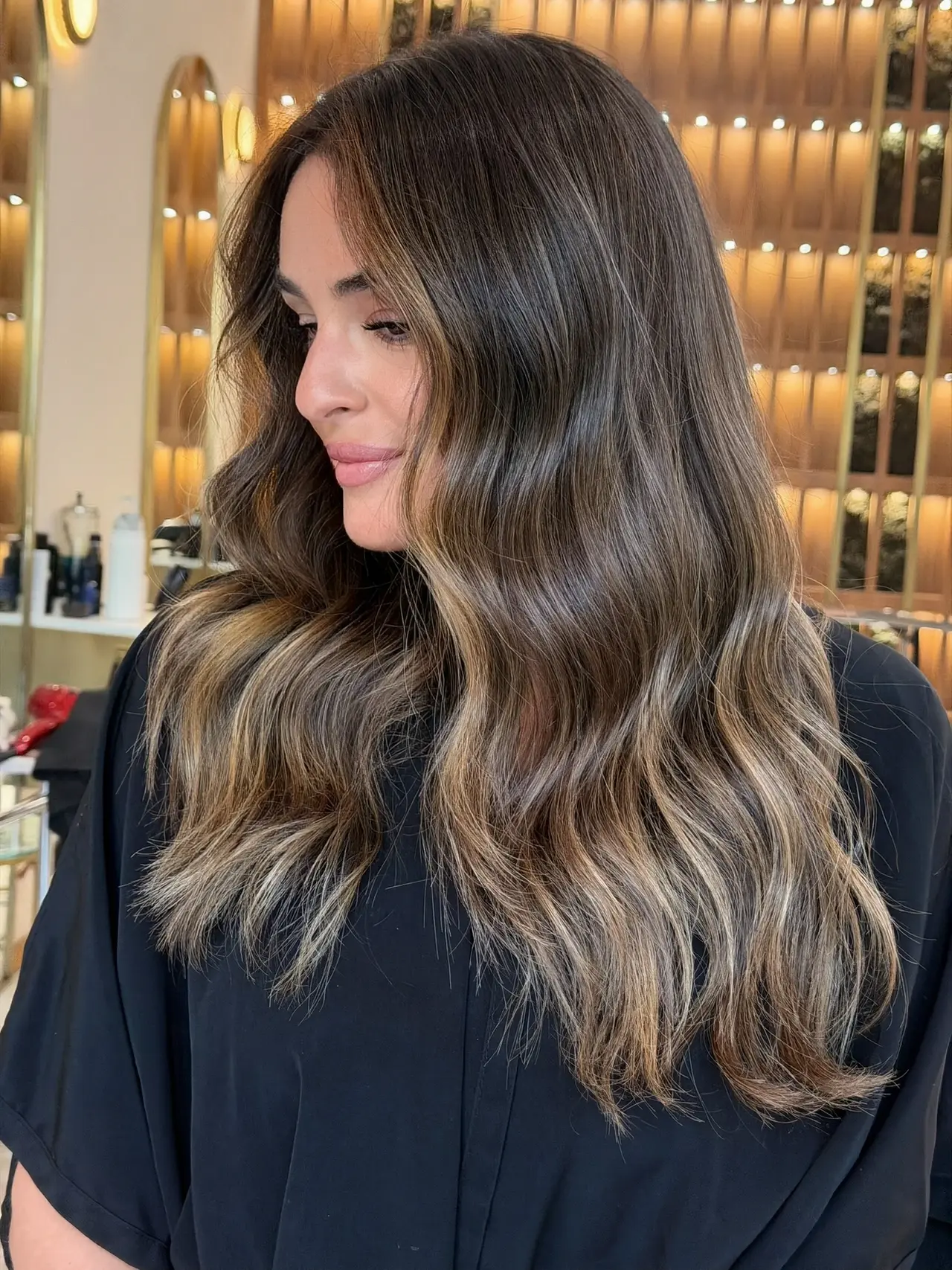 Long brunette hair with soft caramel ribbons, photographed from the side at Rové