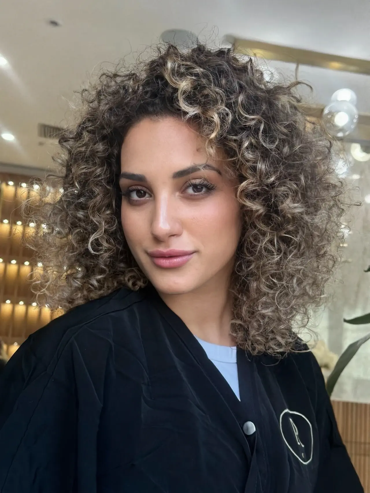 Shoulder-length curls with lighter ribbons and face-framing definition at Rové