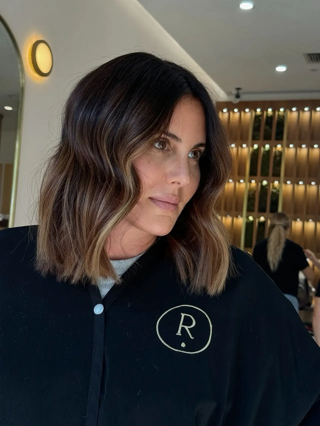 A shoulder-length brunette bob with lighter ends and softly curved waves at Rové