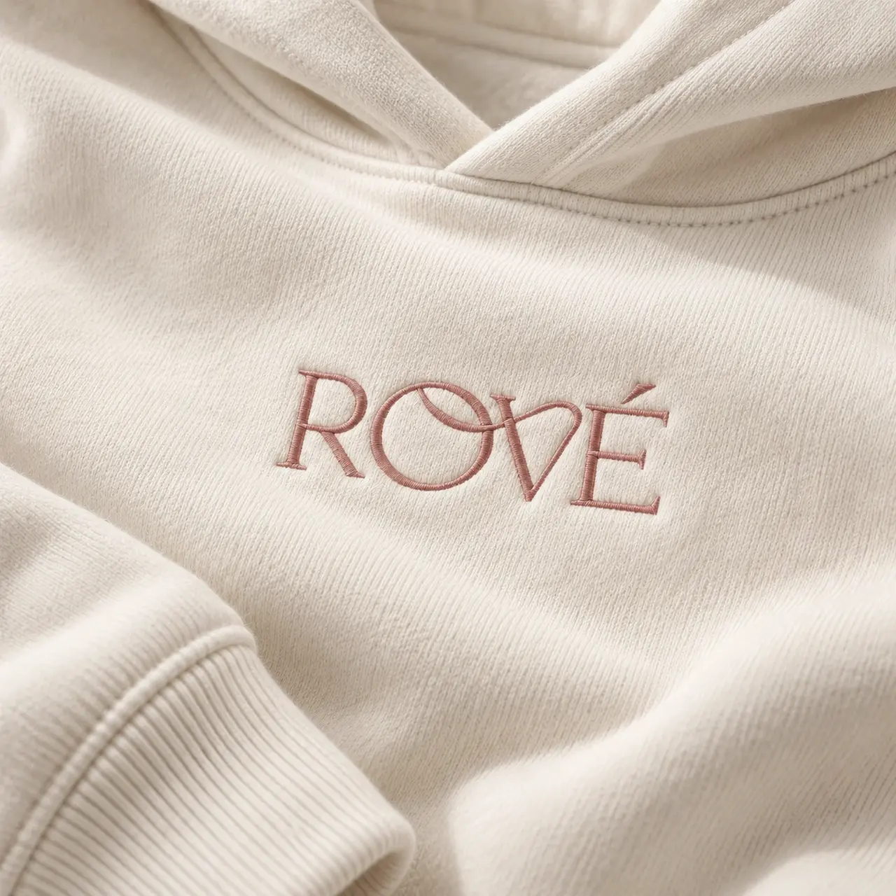 Close-up of rose Rové embroidery on ivory fabric