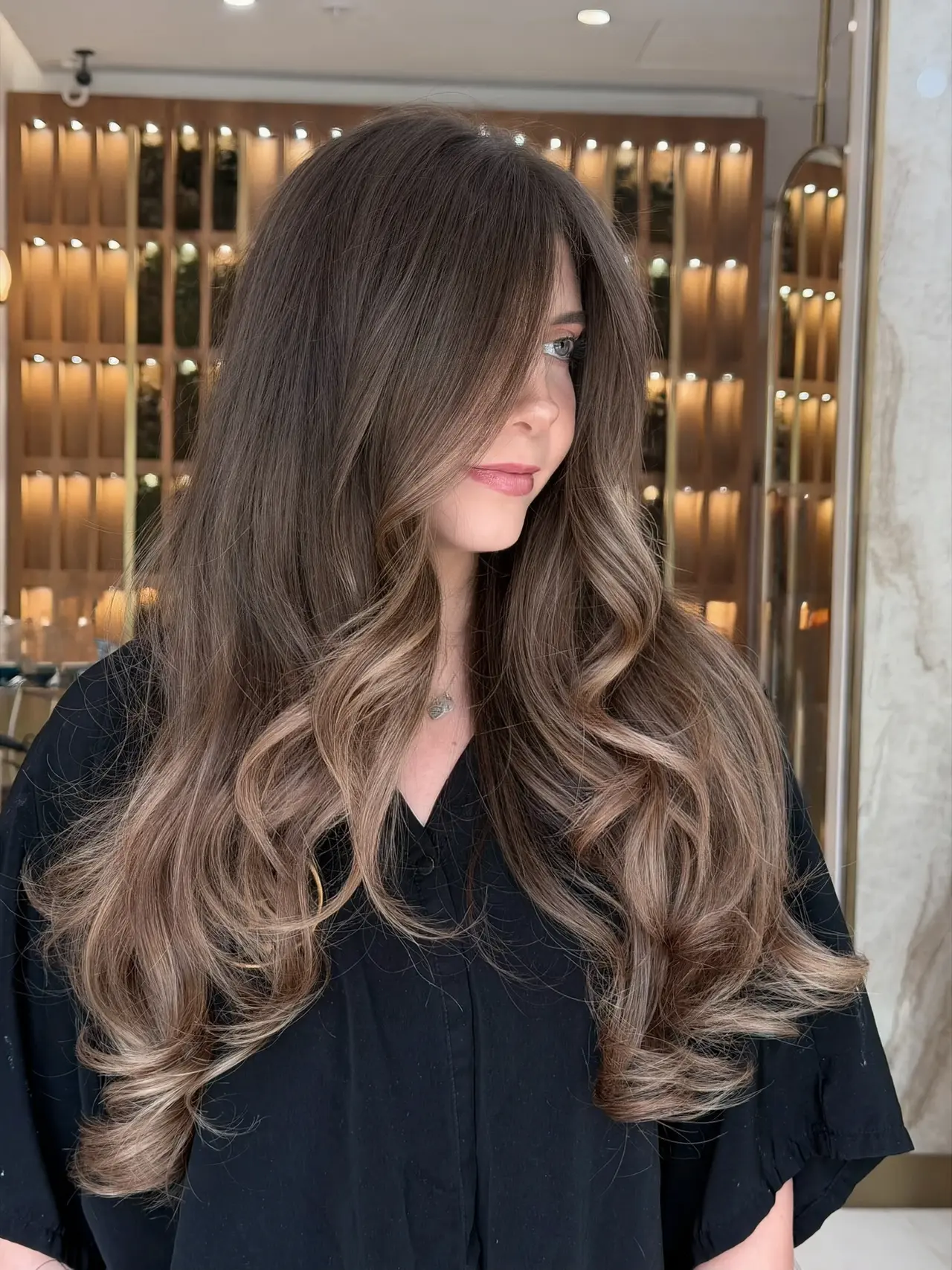 Long brunette layers with lighter face-framing ends at Rové