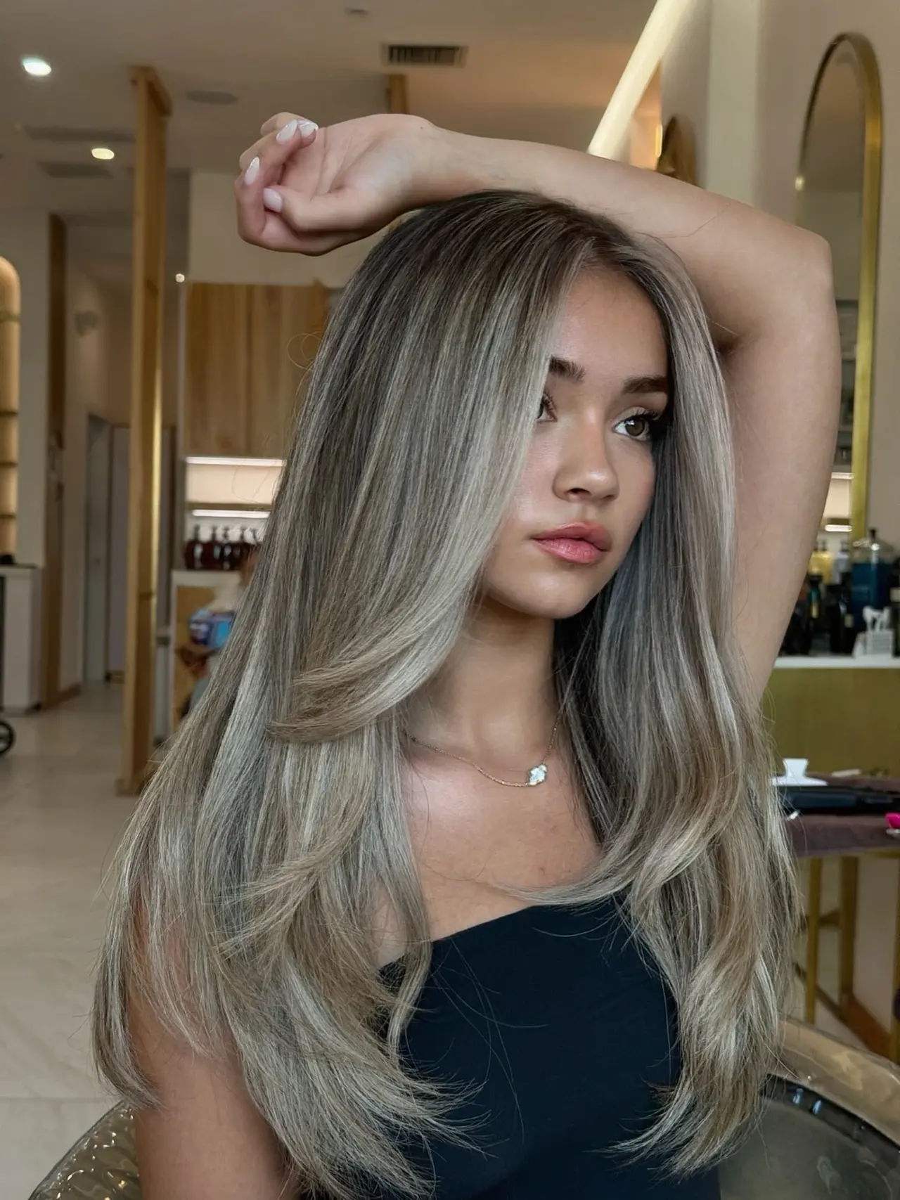 Long smooth beige-blonde layers with a softly blended root and a curved finish at Rové